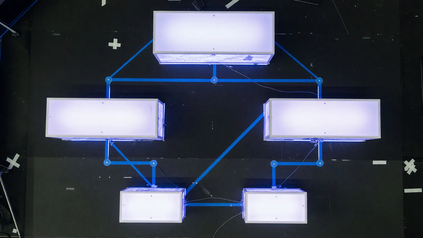 Tournament broadcast audio mixing board with soft blue LED lighting and out-of-focus microphone booms