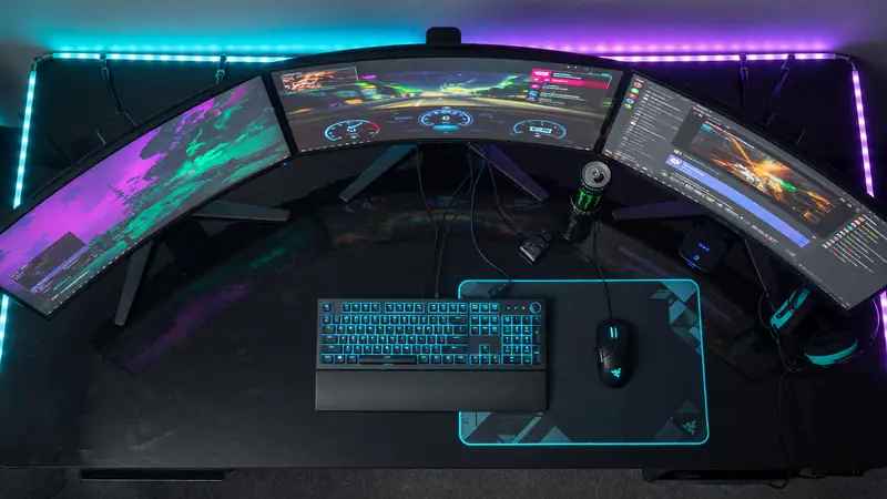 Editorial photograph of an empty competitive gaming arena with cool blue floor strip lights and overhead broadcast cameras